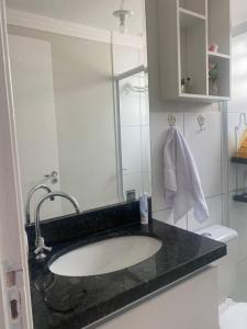 ein Bad mit einem Waschbecken und einem Spiegel in der Unterkunft Apartamento térreo próximo ao Shopping Iguatemi in Votorantim
