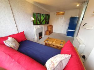 a living room with a red couch and a fireplace at F5 Near BARRY ISLAND PRIVATE AIRPORT Parking x 2 Cars Or Vans Free Wifi Washer Hob & Cooker Welcome Tray Provided in Barry