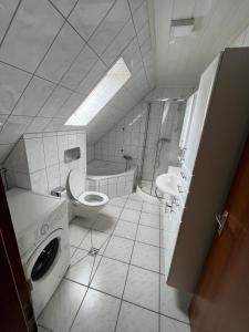 a bathroom with a toilet and a sink and a tub at Ferienzimmer in Bad Mergentheim-Wachbach in Bad Mergentheim