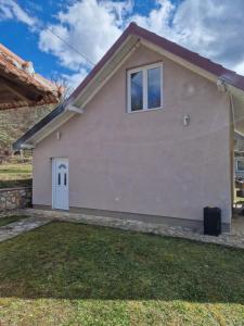 ein Haus mit Rasen davor in der Unterkunft Mountain Home Paravci in Čajniče