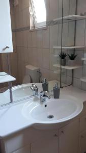 y baño con lavabo blanco y espejo. en Apartman Vesna en Opuzen