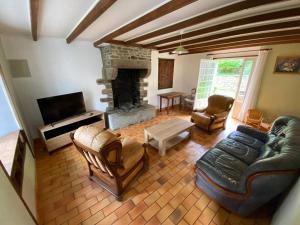 ein Wohnzimmer mit einem Sofa und einem Kamin in der Unterkunft Gîte au coeur de la campagne normande in Ouville