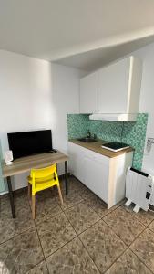 une cuisine avec un tabouret jaune et une table avec une chaise jaune dans l'établissement Chambre d'hôte lloret, à Lloret de Mar