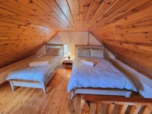 two beds in a room with a wooden ceiling at Cottage Skelligs Coast, Ring of Kerry in Cahersiveen