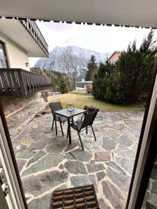 a patio with a table and chairs on a stone patio at Grimming Lodge Tauplitz in Tauplitz