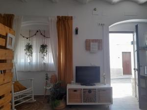 - un salon avec une télévision sur une table dans l'établissement Casa Alkalat, à Alcalá de los Gazules