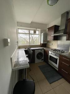 a small kitchen with a stove and a sink at Private rooms with shared facilities in Camden Town in London