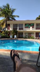 a person with their feet up next to a swimming pool at Casa Sylvie in Sosúa