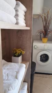 a bathroom with a stack of towels and a washing machine at Apartman Vesna in Opuzen
