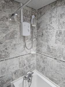 a bathroom with a shower and a bath tub at Exclusive Airbnb haven in Birmingham