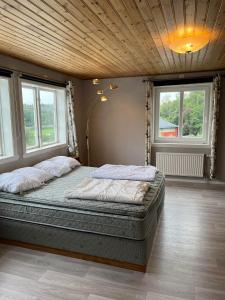 ein Schlafzimmer mit einem großen Bett in einem Zimmer mit Fenstern in der Unterkunft Skräpplinge gård in Mörlunda
