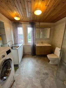 ein Badezimmer mit einem WC, einem Waschbecken und einer Waschmaschine in der Unterkunft Skräpplinge gård in Mörlunda
