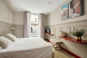 una camera da letto con un letto bianco e una finestra di Petronio Residence a Bologna