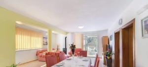 a dining room with a table and red chairs at Apartman Vesna in Opuzen