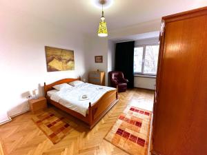um quarto com uma cama e uma cadeira em Ultracentral Apartment 4 rooms - Old City Center -120 square meters - em Bucareste