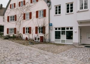 a cobblestone street in front of a white building at Charmante Ferienwohnung in der Altstadt in Landsberg am Lech