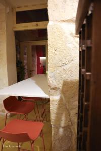 - une table blanche et deux chaises rouges dans la chambre dans l'établissement 150 years old Maltese Townhouse: Dar Emanuela, à Cospicua