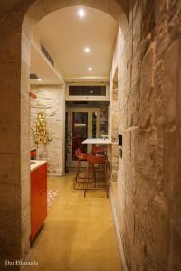 - une cuisine avec un mur en pierre et une table dans l'établissement 150 years old Maltese Townhouse: Dar Emanuela, à Cospicua