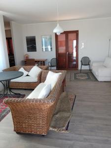 a living room with wicker furniture and a table at Villa Rita in Corigliano Calabro