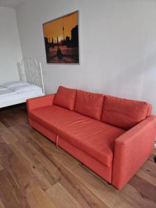 un sofá rojo sentado en una sala de estar en City Studio Apartment for 4, near Sonnenallee, en Berlín