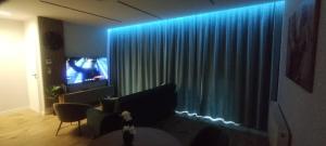 a living room with a couch and a television with blue lights at Apartament,,Nuta'' in Gniezno