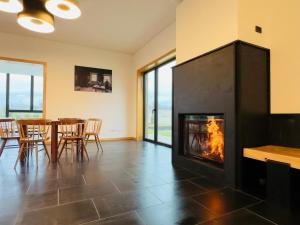 a fireplace in a living room with a table and chairs at PÉ AZUL - Turismo em Espaço Rural - Parque Natural de Montesinho in Bragança