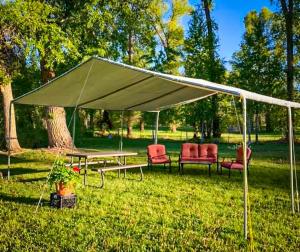 a tent with chairs and a table in the grass at Vista Del Rio Lodge in Chama