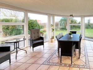un porche cubierto con mesa y sillas en Three-Bedroom Holiday home in Hemmet 68, en Falen
