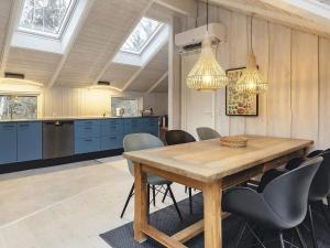 cocina y comedor con mesa de madera y sillas en 4 person holiday home in Martofte, en Martofte