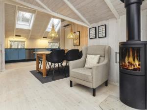 sala de estar con chimenea, silla y mesa en 4 person holiday home in Martofte, en Martofte