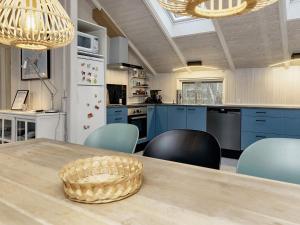 una cucina con armadi blu e tavolo con sedie di 4 person holiday home in Martofte a Martofte