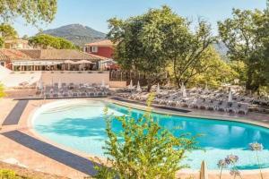 - une piscine dans un complexe avec des chaises dans l'établissement Vue mer et St Tropez 2 chambres wifi-climatisation piscines, à Grimaud