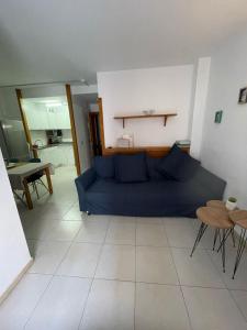 a living room with a blue couch and a table at Apartamento con piscina en el centro de Blanes in Blanes