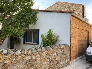 a house with a stone wall and a fence at Mazet avec jardin in Saint-Bauzille-de-Putois