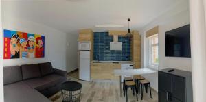 a living room with a couch and a table and a kitchen at Apartamentos Zenit Mar in Noja
