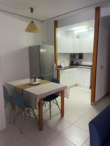 una cucina e una sala da pranzo con tavolo e sedie di Apartamento con piscina en el centro de Blanes a Blanes