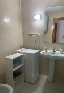 a white bathroom with a sink and a mirror at Apartamento con piscina en el centro de Blanes in Blanes