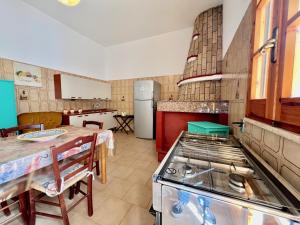 a kitchen with a table and a stove in it at Casa per vacanze Ludovica in Avetrana