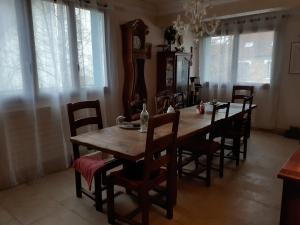 a dining room with a wooden table and chairs at chambre d'hôte "Chambre dans une maison pleine de vie" in Saint-Rémy-lès-Chevreuse