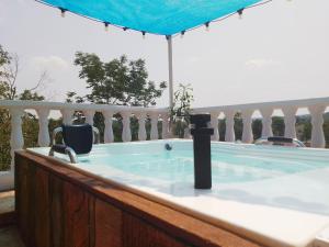 a hot tub on a balcony with a blue umbrella at Cabaña Aldea Santorini in Doradal