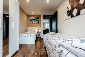 1 Schlafzimmer mit 2 Betten und einem Spiegel in der Unterkunft Happy Place - Happy Apartamenty Mielec in Mielec