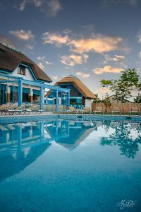 un resort con piscina con sedie e un edificio di Pensiunea Briza Marii Jurilovca a Jurilovca