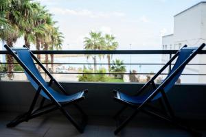 Duas cadeiras sentadas numa varanda com vista para o oceano em Casa Vacanza Acquamarina em Porto Torres