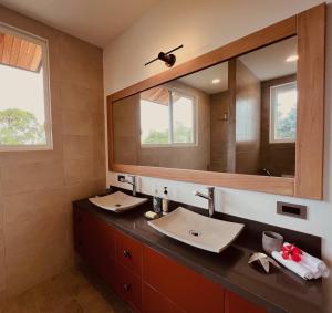 baño con lavabo y espejo grande en Villa Peregrina, en Puerto Ayora