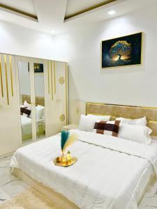 um quarto com uma grande cama branca e um espelho em Résidence Mounir em Thiès