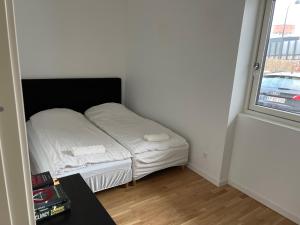 małe łóżko w pokoju z oknem w obiekcie Lyngby NO SMOKING Apt w mieście Kongens Lyngby