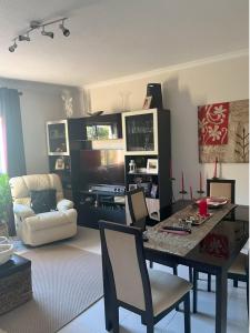 ein Wohnzimmer mit einem Tisch und Stühlen sowie ein Wohnzimmer in der Unterkunft Apartamento com boa localização e Conforto in Póvoa de Santa Iria