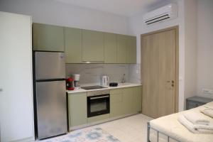 a kitchen with green cabinets and a refrigerator at Lythri Studios in Chios