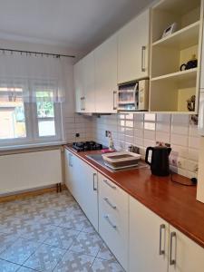 a kitchen with white cabinets and a wooden counter top at Mieszkanie Dalia in Karwia