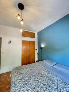 1 dormitorio con cama y pared azul en El PH de Chacarita en Buenos Aires